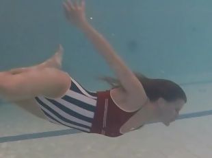 Leggy girl swims and strips naked in pool