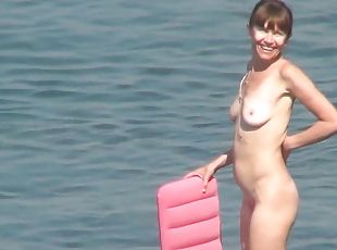 Sexy chick is walking naked on the beach